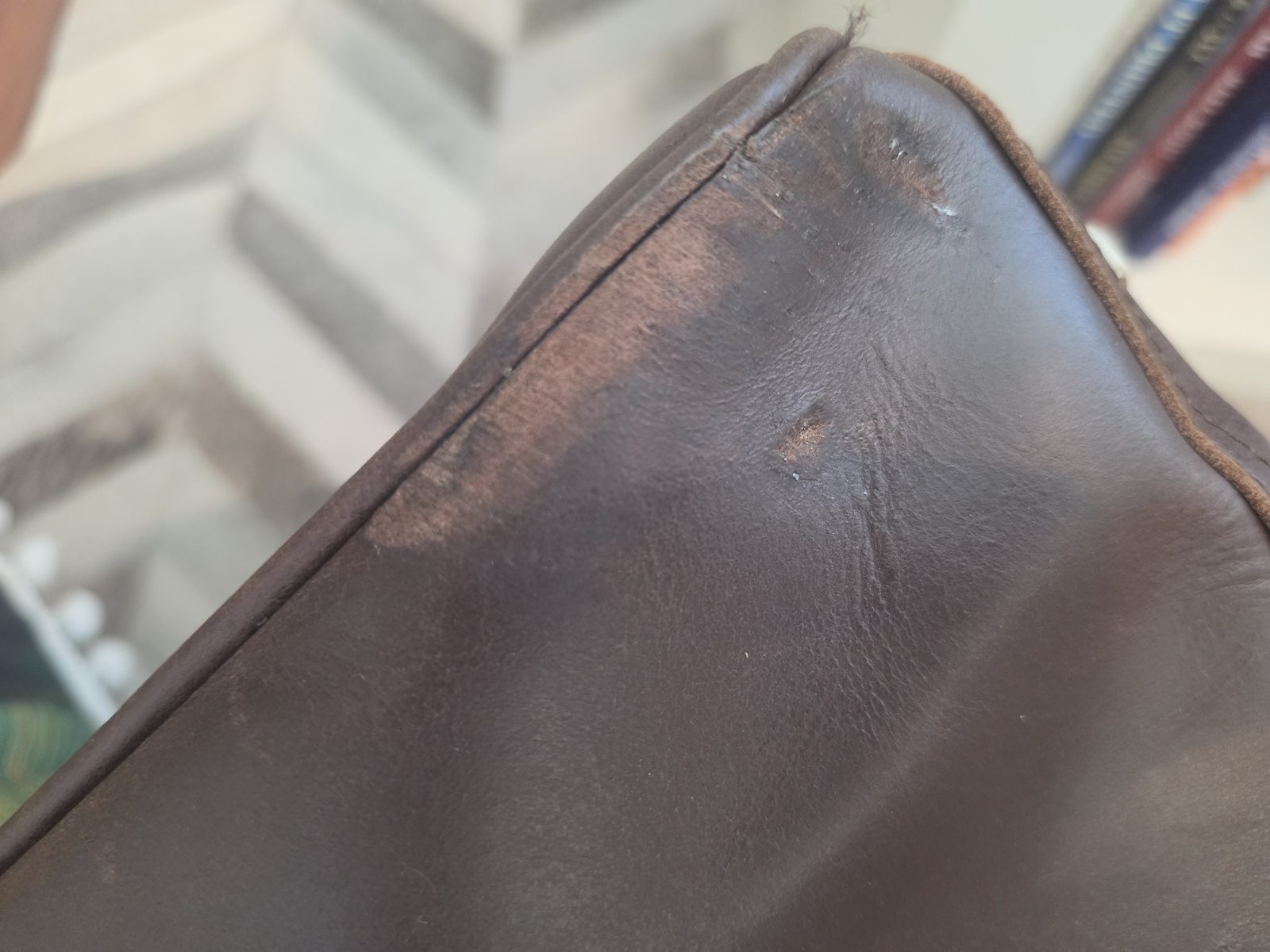 Close-up of scuffed and marked leather on the duffel bag